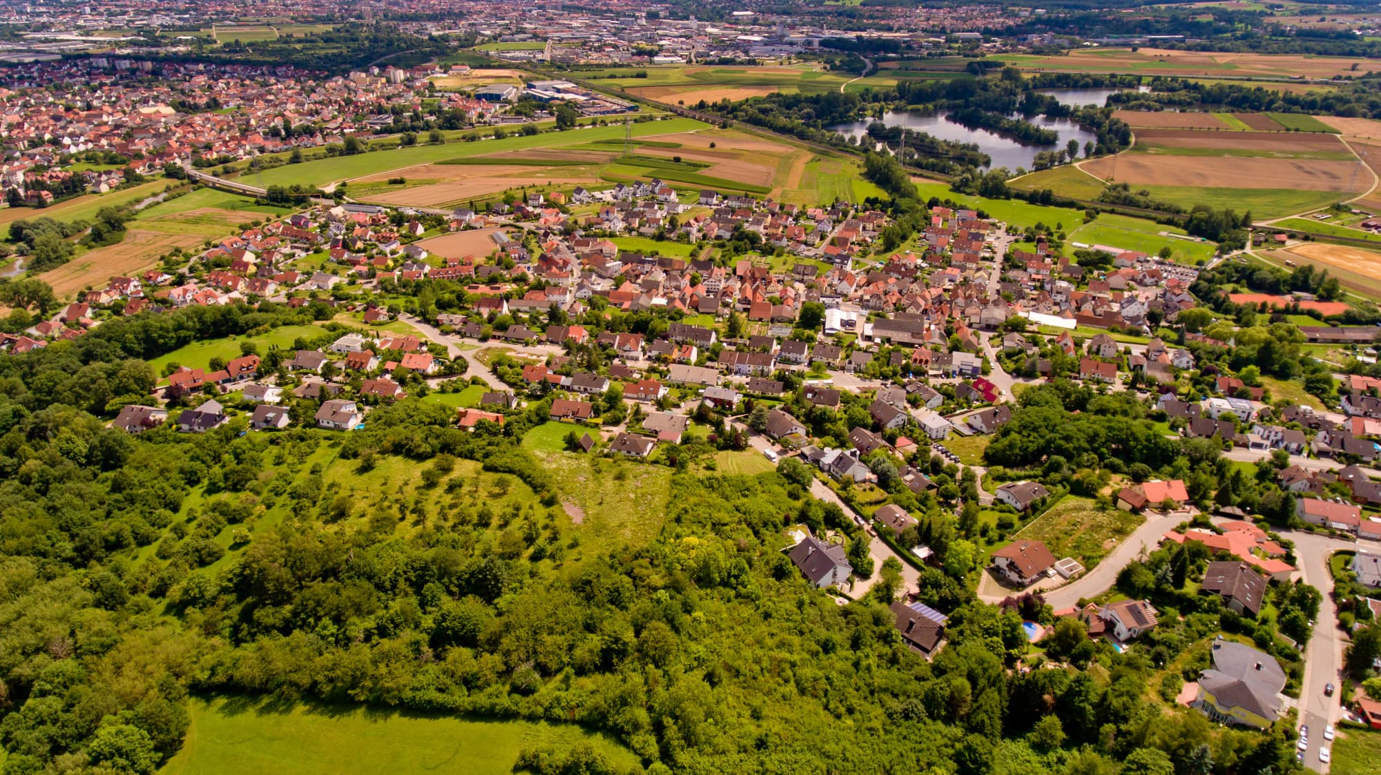 Luchtfoto van een dorp met woonwijken en velden