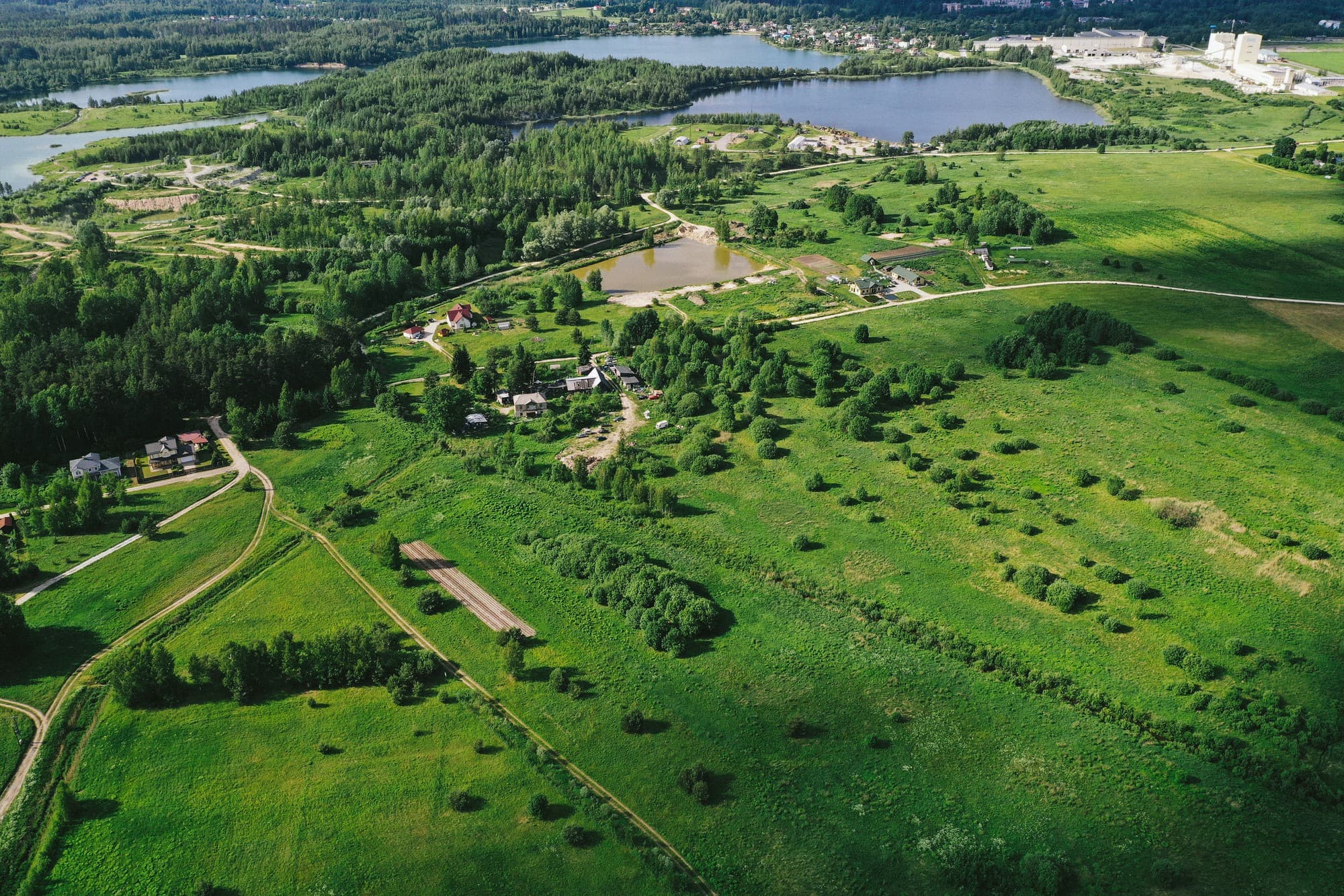 Luchtfoto van een groene omgeving met meren en woningen